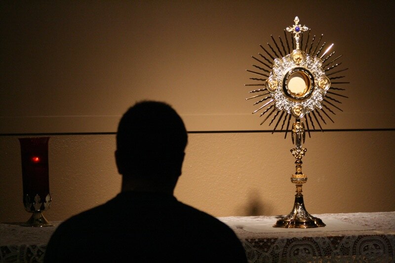 A Cursillo participant praying before the Blessed Sacrament during Adoration